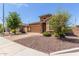 Cozy single-story home featuring a stone facade, two-car garage, and neatly arranged desert landscaping at 296 N Jesse St, Chandler, AZ 85225