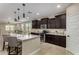 Bright kitchen featuring a large island with seating, dark cabinets, and tile flooring at 296 N Jesse St, Chandler, AZ 85225