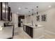 Spacious kitchen featuring dark cabinets, stainless steel appliances, and an island with a sink at 296 N Jesse St, Chandler, AZ 85225