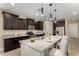 Well-lit kitchen featuring dark cabinets, stainless steel appliances, and a large island with seating at 296 N Jesse St, Chandler, AZ 85225