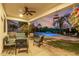 Inviting covered patio overlooking a sparkling pool, lush landscaping, and comfortable seating for outdoor living at 2977 E County Down Dr, Chandler, AZ 85249