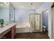 Well-lit bathroom features shower, bathtub, vanity, and a decorative stained glass window at 2977 E County Down Dr, Chandler, AZ 85249