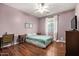 Comfortable bedroom with wood floors, ceiling fan, and a bright window with drapes at 2977 E County Down Dr, Chandler, AZ 85249