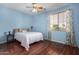 Bedroom with wood floors, light blue walls, and a window with blinds and drapes at 2977 E County Down Dr, Chandler, AZ 85249