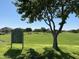 A serene park scene with a tree, well manicured lawn, and a sign for Sun River residents at 2977 E County Down Dr, Chandler, AZ 85249
