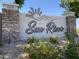 The community sign welcomes residents and visitors to Sun River with stone pillars and lush greenery at 2977 E County Down Dr, Chandler, AZ 85249
