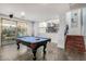 A bright game room features a pool table, access to outside, and stairs to the second story at 2977 E County Down Dr, Chandler, AZ 85249