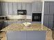 A kitchen with an island, blue cabinets, granite countertops, and stainless steel appliances at 2977 E County Down Dr, Chandler, AZ 85249