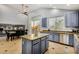 Features a kitchen with an island, blue cabinets, granite countertops, and a dining area nearby at 2977 E County Down Dr, Chandler, AZ 85249