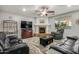 Inviting living room featuring a fireplace, ceiling fan and black leather recliners at 2977 E County Down Dr, Chandler, AZ 85249