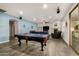 Spacious living room features a fireplace, comfortable seating, and a pool table for entertainment at 2977 E County Down Dr, Chandler, AZ 85249