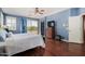 The main bedroom offers blue walls, wood floors, a ceiling fan, and balcony access at 2977 E County Down Dr, Chandler, AZ 85249