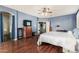 Spacious main bedroom features wood floors, ceiling fan, and access to an ensuite bathroom at 2977 E County Down Dr, Chandler, AZ 85249