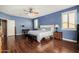 A main bedroom featuring blue walls, wood floors, ceiling fan, and traditional furnishings at 2977 E County Down Dr, Chandler, AZ 85249