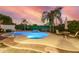 Lush backyard featuring a sparkling pool with a rock waterfall, and a desert sunset at 2977 E County Down Dr, Chandler, AZ 85249
