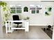 Sun-filled home office with tile floors, modern desk, multiple windows, and fitness equipment at 3517 E Monterosa St, Phoenix, AZ 85018