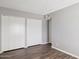 Bedroom featuring light gray walls, wood floors, and ample closet space with white closet doors at 3605 W Bethany Home Rd # 7, Phoenix, AZ 85019