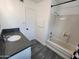 This bathroom features a shower-tub combination with a gray, granite vanity and gray wood-look floors at 4210 W Solano Dr, Phoenix, AZ 85019