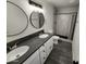 Bathroom featuring dual sinks, marble shower, and modern fixtures at 4210 W Solano Dr, Phoenix, AZ 85019