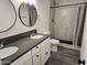 Bathroom featuring dual sinks, marble shower, and modern fixtures at 4210 W Solano Dr, Phoenix, AZ 85019