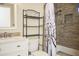 Bathroom with white vanity, modern fixtures, and tiled shower with a patterned curtain at 441 E Encinas Ave, Gilbert, AZ 85234