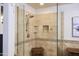 Tiled walk-in shower with glass partition, built-in shelves, and a convenient shower bench at 441 E Encinas Ave, Gilbert, AZ 85234