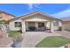 Exterior of the home with a covered patio and artificial turf in the landscaped backyard at 46141 W Amsterdam Rd, Maricopa, AZ 85139