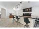 Stylish wet bar with granite countertops, custom cabinetry, and seating for entertaining guests at 46141 W Amsterdam Rd, Maricopa, AZ 85139