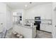 Bright kitchen showcasing an island with sink, white cabinets, and modern appliances, offering functionality and style at 46141 W Amsterdam Rd, Maricopa, AZ 85139