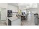 Open kitchen and dining area with island, stainless steel appliances, and wood-style flooring at 46141 W Amsterdam Rd, Maricopa, AZ 85139