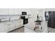 Well-lit kitchen with white cabinets, grey countertops, and stainless steel appliances at 46141 W Amsterdam Rd, Maricopa, AZ 85139