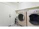 Functional laundry room featuring a washer, dryer, storage shelving, and convenient access to the outdoors at 46141 W Amsterdam Rd, Maricopa, AZ 85139
