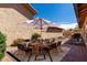 A backyard patio offers outdoor dining with the umbrella-covered table, grill, and desert landscaping at 5221 E Tunder Cir, Phoenix, AZ 85044