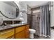 The renovated bathroom features a sink with granite counter, a shower with seating, and glass block at 5221 E Tunder Cir, Phoenix, AZ 85044