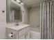 Bathroom features a white vanity, framed mirror, tiled floors, tub, and shower with patterned shower curtain at 536 S Evergreen Rd, Tempe, AZ 85288