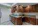 Galley kitchen with stainless steel appliances, light countertops, tiled floors, and wood cabinetry at 536 S Evergreen Rd, Tempe, AZ 85288