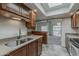Bright kitchen featuring stainless steel sink, wood cabinets, granite counters, and tiled floors at 536 S Evergreen Rd, Tempe, AZ 85288