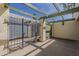 Secluded backyard patio with a metal gate, providing a secure and private outdoor area, complemented by a green pergola at 536 S Evergreen Rd, Tempe, AZ 85288