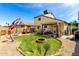 A well-kept backyard features green grass, patio seating, and a play area for children at 542 N Orlando Cir, Mesa, AZ 85205