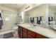 Well-lit bathroom with a spacious countertop, sleek cabinets, and a shower with a glass door at 542 N Orlando Cir, Mesa, AZ 85205