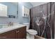 A well-lit bathroom features a vanity, toilet, storage cabinet, and decorative shower curtain at 542 N Orlando Cir, Mesa, AZ 85205