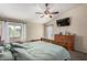 Bright bedroom with a ceiling fan, TV, and a cozy king-size bed, perfect for relaxing after a long day at 542 N Orlando Cir, Mesa, AZ 85205