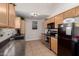Efficient kitchen featuring tile floors, wooden cabinets, black appliances, and ample counter space at 542 N Orlando Cir, Mesa, AZ 85205