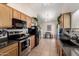 Efficient kitchen showcasing tile floors, wood cabinets, black appliances, and plenty of counter space at 542 N Orlando Cir, Mesa, AZ 85205