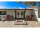 Inviting back patio featuring an outdoor fireplace, comfortable seating, and access through French doors at 613 E Vista Ave, Phoenix, AZ 85020