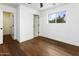 Minimalist bedroom with wood floors, white walls, and natural light from the single window at 613 E Vista Ave, Phoenix, AZ 85020