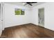 Bedroom features wood floors, white walls, a ceiling fan and an ensuite bathroom at 613 E Vista Ave, Phoenix, AZ 85020