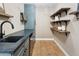 Laundry room features blue cabinets, dark stone countertop, utility sink and wood shelves at 613 E Vista Ave, Phoenix, AZ 85020
