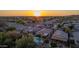 Scenic aerial view of a tranquil residential area with a community pool and a picturesque sunset backdrop at 6853 S Russet Sky Way, Gold Canyon, AZ 85118