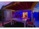 Back patio with rustic dining set, TV, shed, and festive outdoor lighting perfect for entertaining at 6853 S Russet Sky Way, Gold Canyon, AZ 85118